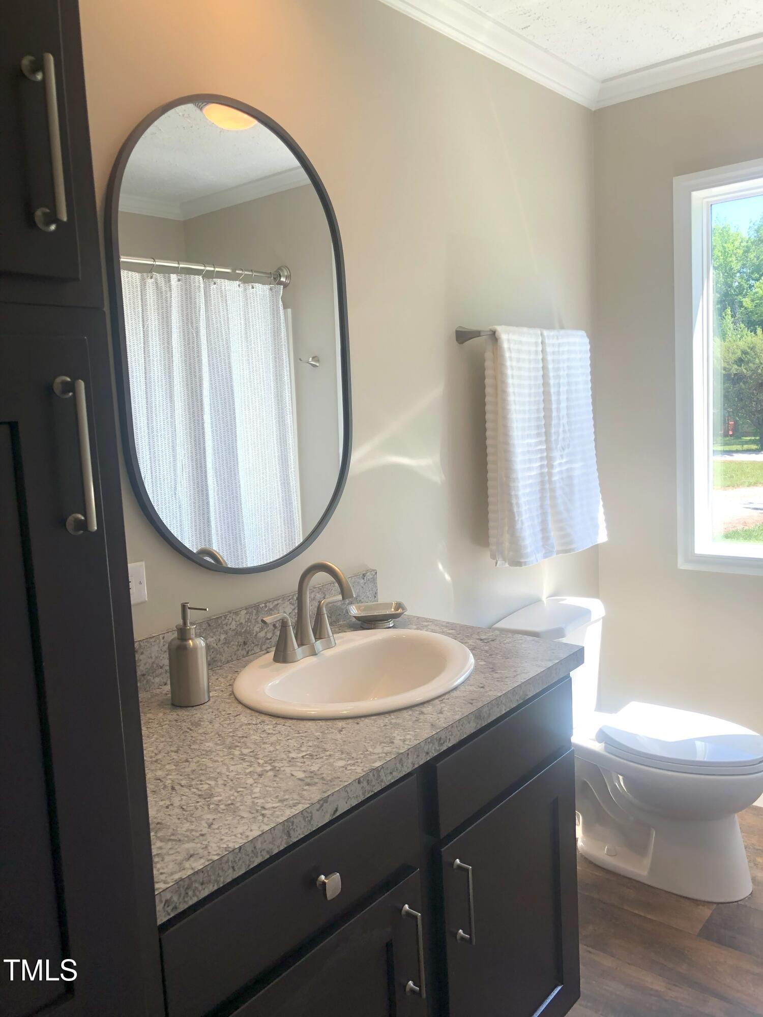 550 Saplin Branch Road Timberlake, NC 27583 - Photo 24 of 33 a bathroom with a granite countertop toilet a sink and a mirror
