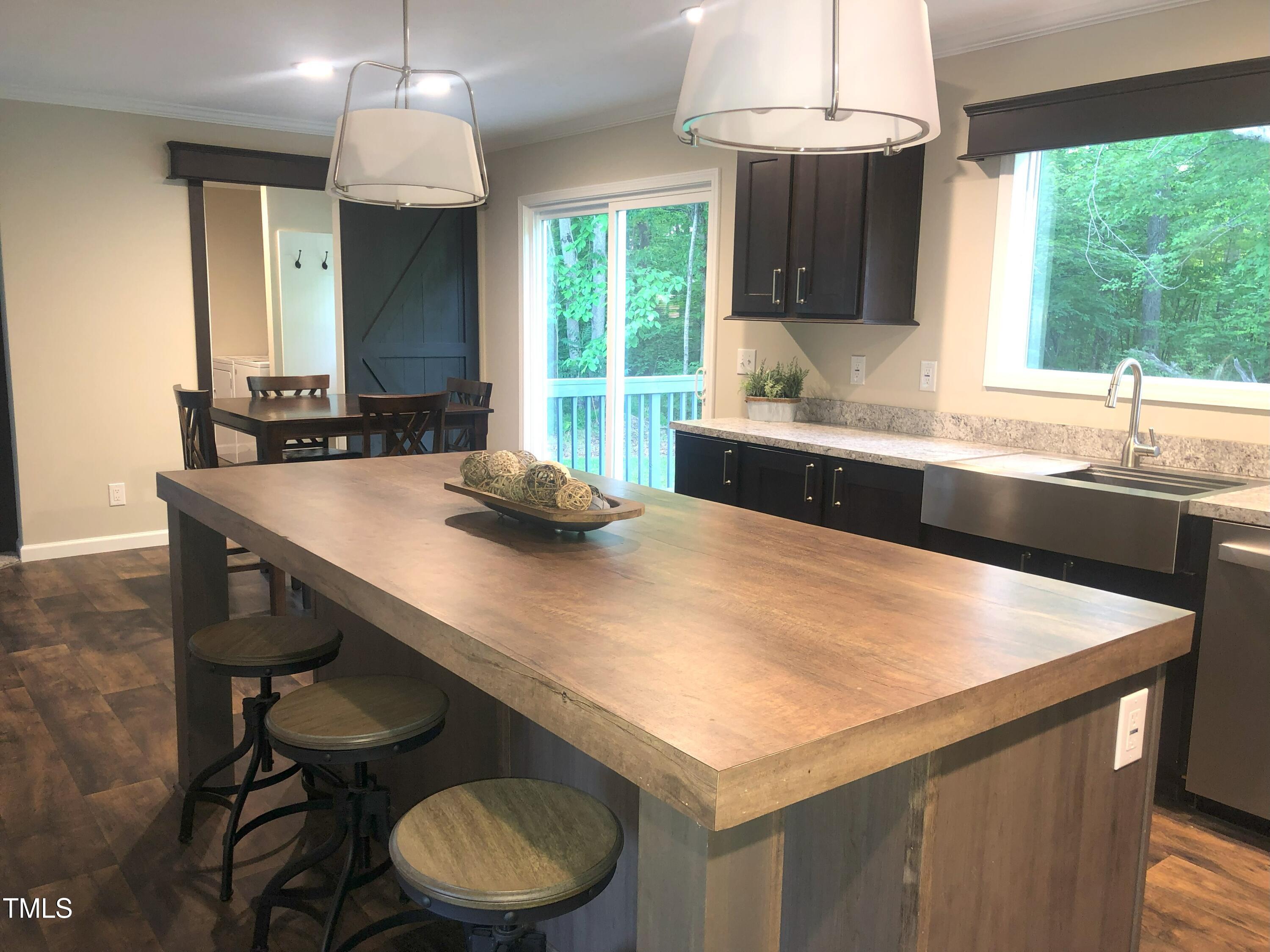 550 Saplin Branch Road Timberlake, NC 27583 - Photo 6 of 33 a kitchen with a table chairs sink and large window