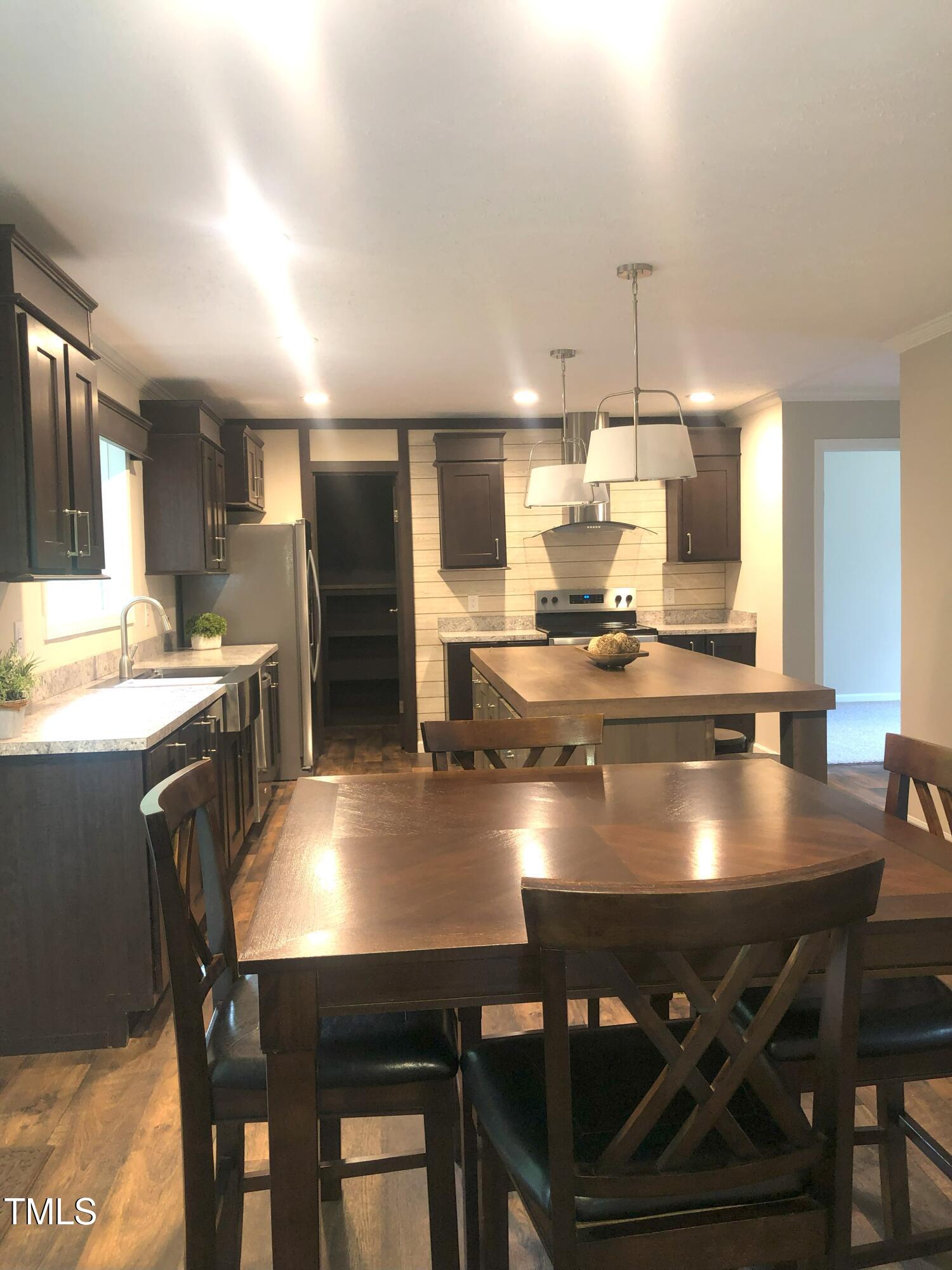 550 Saplin Branch Road Timberlake, NC 27583 - Photo 8 of 33 a kitchen with a dining table chairs and refrigerator