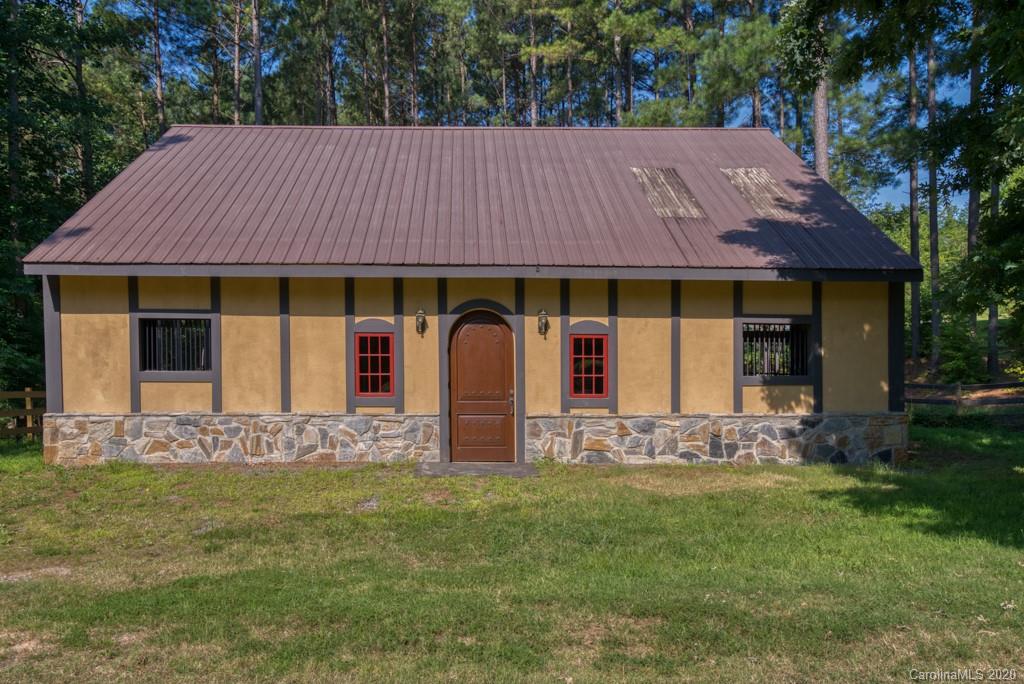 6074 Hunting Country Road Tryon, NC 28782 - Photo 14 of 34 a front view of a house with a garden and yard