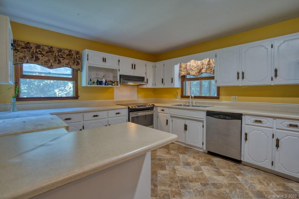 6074 Hunting Country Road Tryon, NC 28782 - Photo 29 of 34 a kitchen with stainless steel appliances granite countertop a sink and cabinets