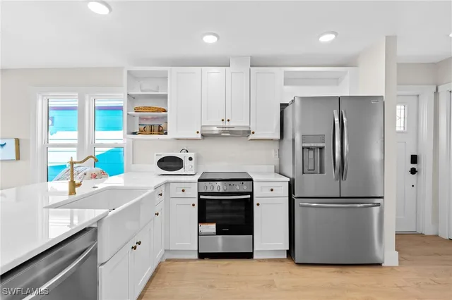 a kitchen with a refrigerator and a stove top oven