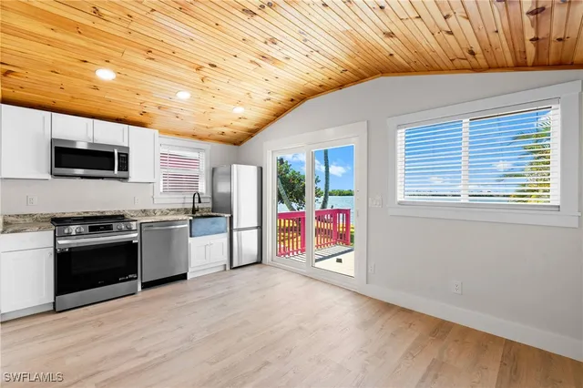 a kitchen with stainless steel appliances granite countertop a refrigerator a stove top oven a sink and dishwasher