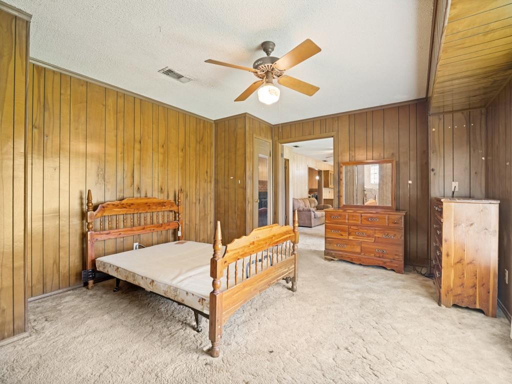 1081 Wright Street Terrell, TX 75160 - Photo 14 of 29 Interior room featuring wood paneling on walls, white ceiling, and light-toned carpet flooring