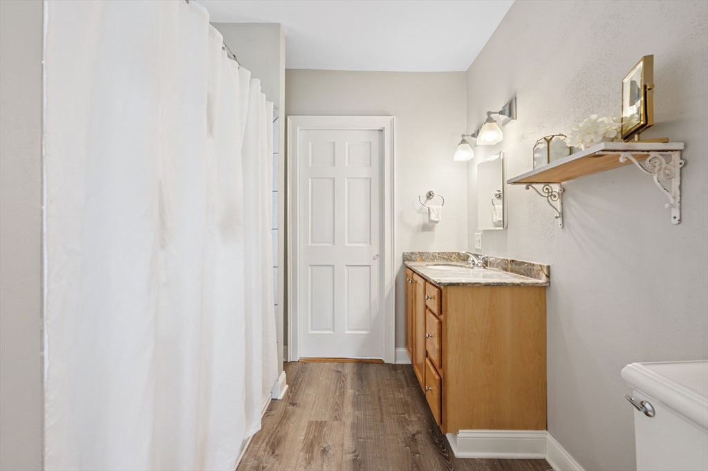 173 H Street, Unit 2 Boston, MA 02127 - Photo 16 of 26 a bathroom with a granite countertop sink and a mirror