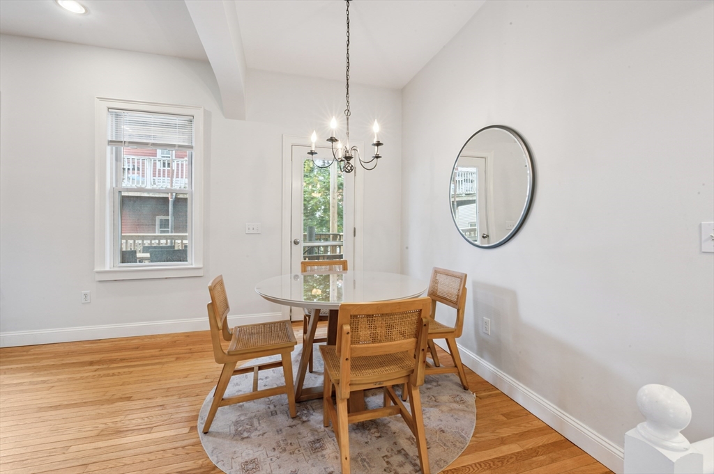 173 H Street, Unit 2 Boston, MA 02127 - Photo 9 of 26 a dining room with furniture a mirror and wooden floor