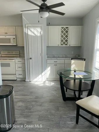 a kitchen with stainless steel appliances kitchen island granite countertop a table chairs and a refrigerator