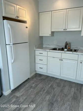 a kitchen with stainless steel appliances white cabinets and a refrigerator