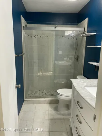 a bathroom with a granite countertop sink toilet and shower