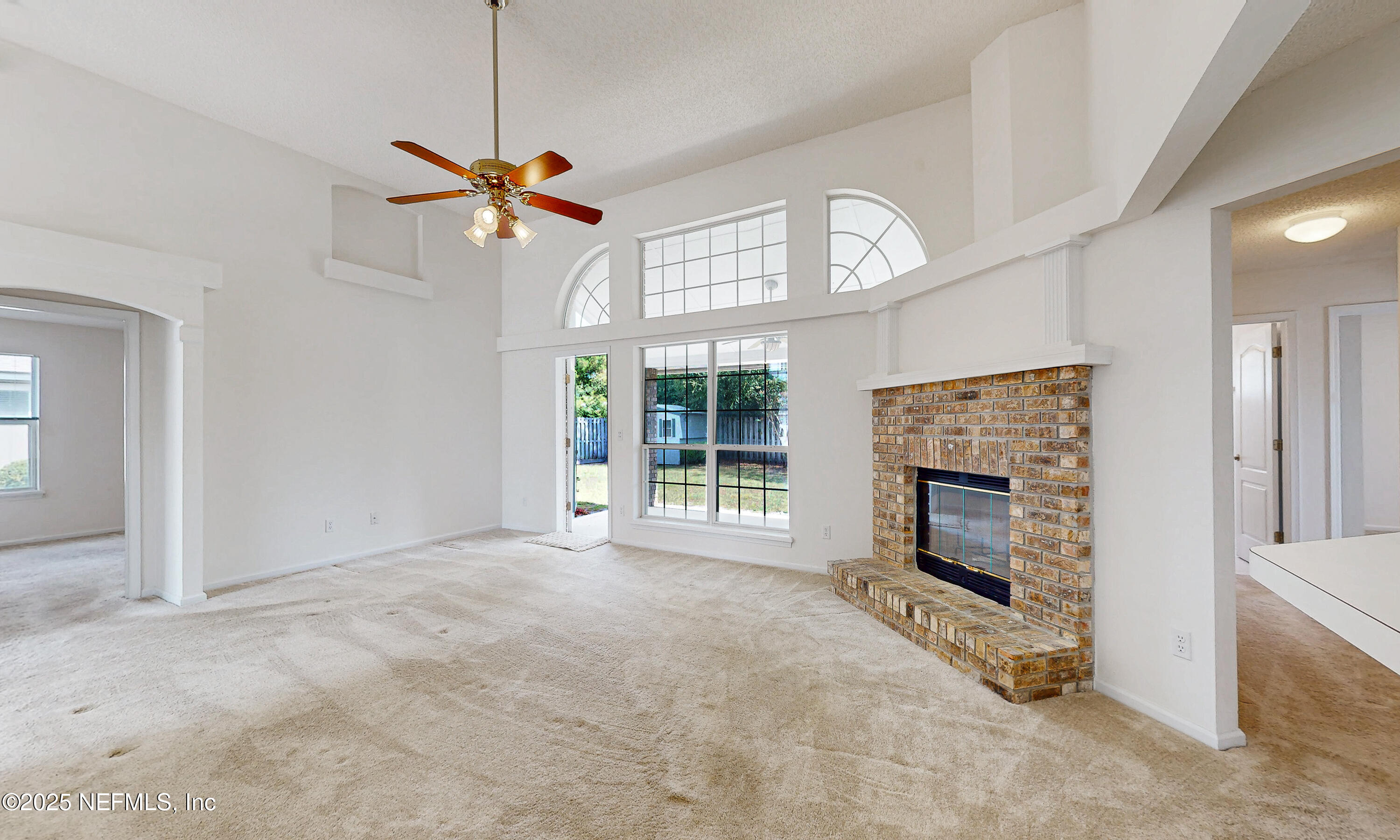 2031 Canyon Rim Place Middleburg, FL 32068 - Photo 33 of 38 a view of a livingroom with a fireplace a ceiling fan and windows