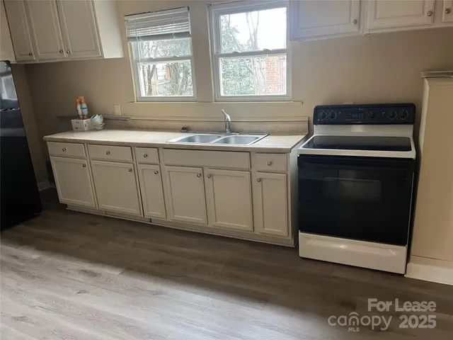 a kitchen with granite countertop cabinets stainless steel appliances a sink and a window