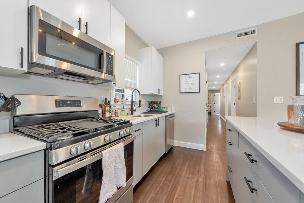 777 Columbia Road, Unit 3 Boston, MA 02125 - Photo 3 of 21 a kitchen with stainless steel appliances granite countertop a stove a sink and a microwave