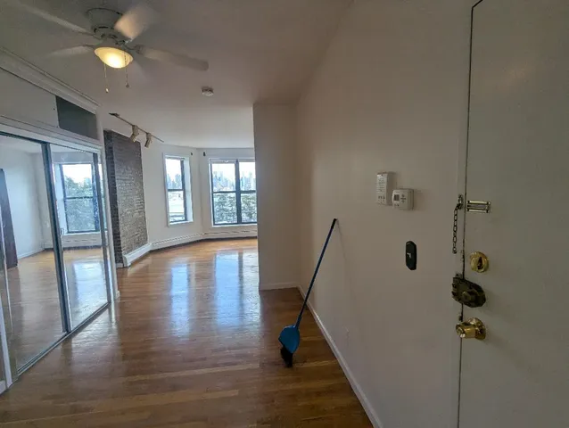 a view of a hallway with wooden floor and a living room