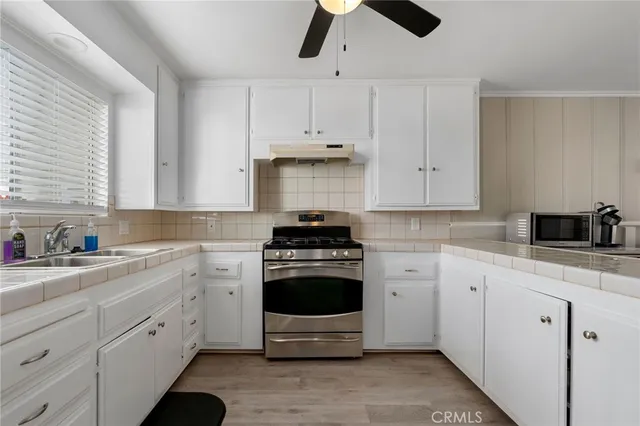 a kitchen with white cabinets and appliances