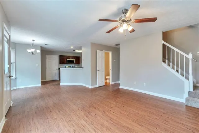 a view of a livingroom with a kitchen stove wooden floor and a kitchen