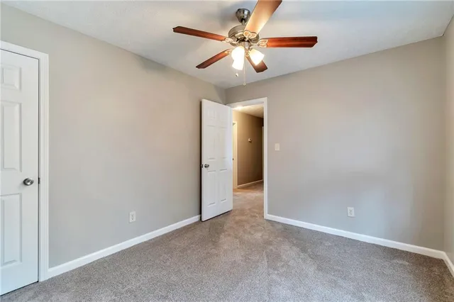an empty room with a chandelier fan and a ceiling fan