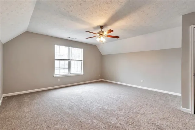 an empty room with windows and chandelier fan