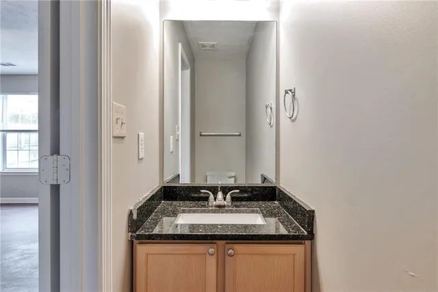 a bathroom with a granite countertop sink and a mirror