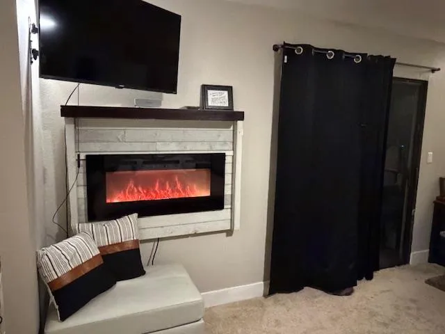 a living room with furniture a fireplace and a flat screen tv
