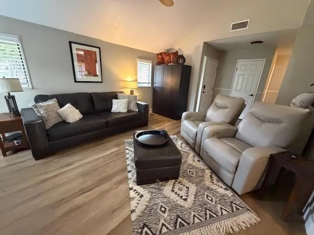 a living room with stainless steel appliances kitchen island granite countertop furniture a rug kitchen view and a chandelier