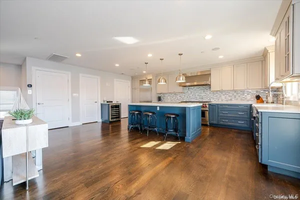 a kitchen with stainless steel appliances granite countertop a sink counter space and wooden floor