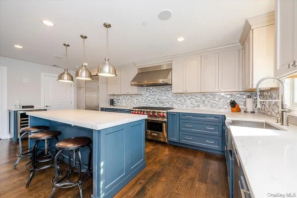 a kitchen with a stove a window and chairs