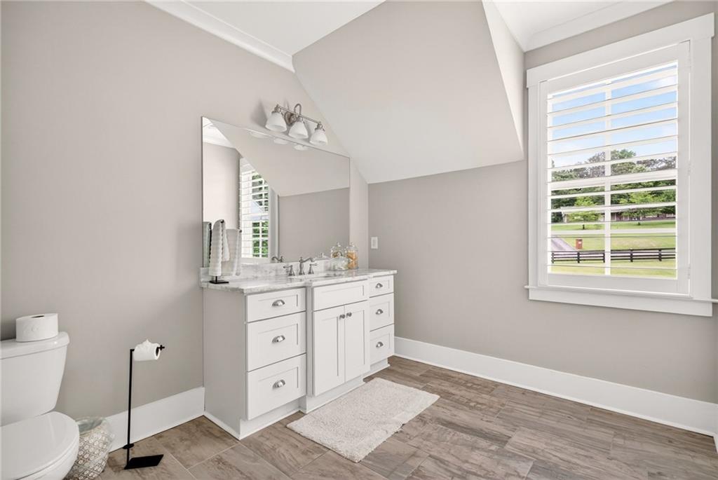 13460 New Providence Road Milton, GA 30004 - Photo 30 of 60 a spacious bathroom with a granite countertop toilet a sink and a mirror