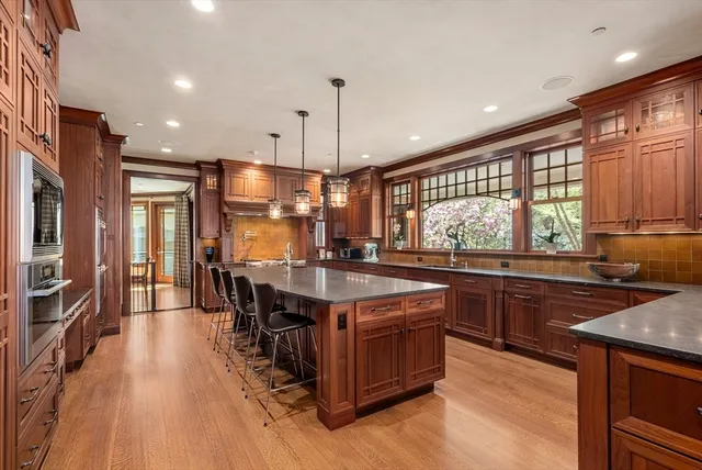 a kitchen with stainless steel appliances granite countertop a stove and a wooden floors