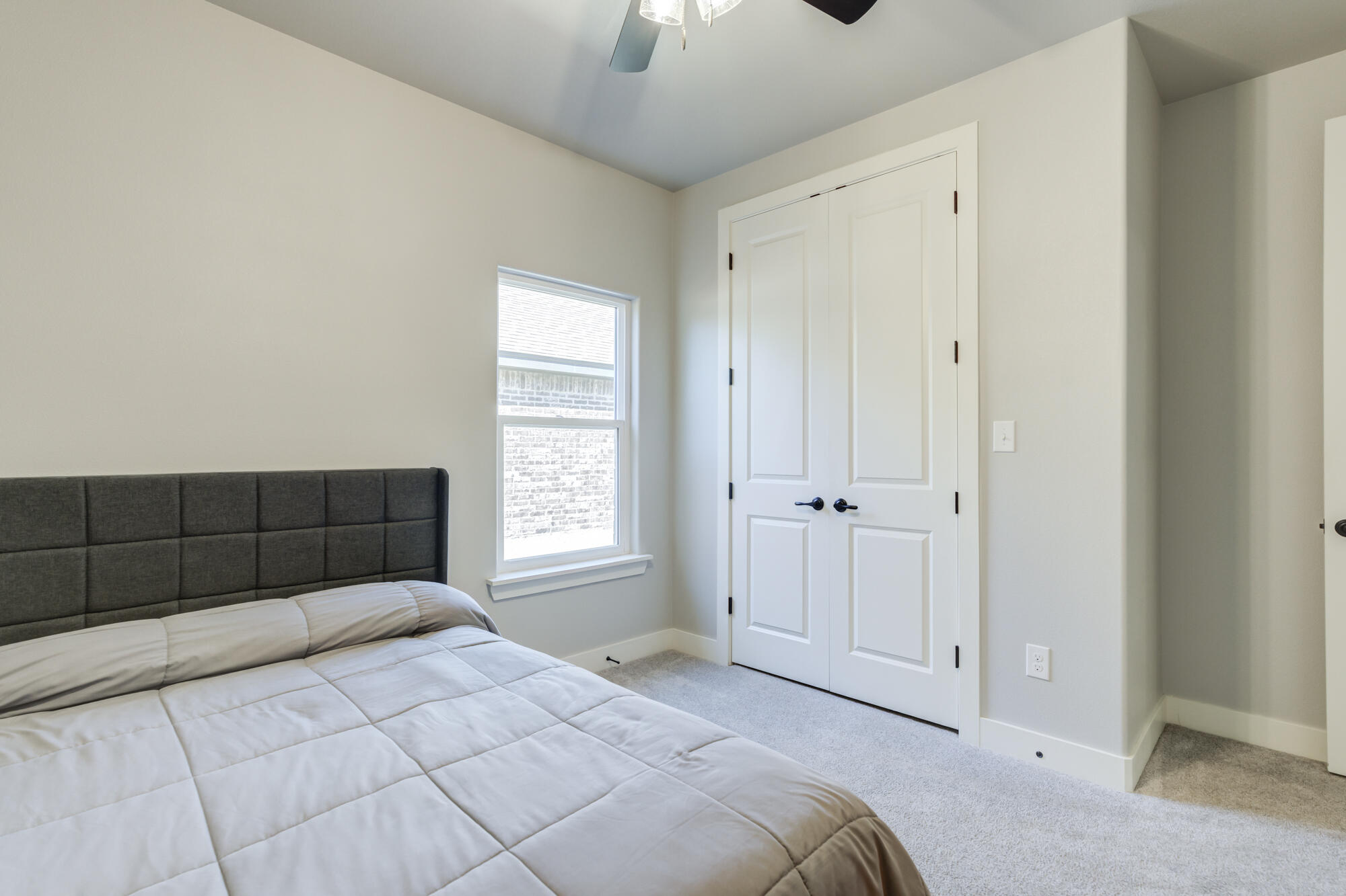 5611 117th Street Lubbock, TX 79424 - Photo 24 of 30 a bedroom with a bed and a chandelier fan