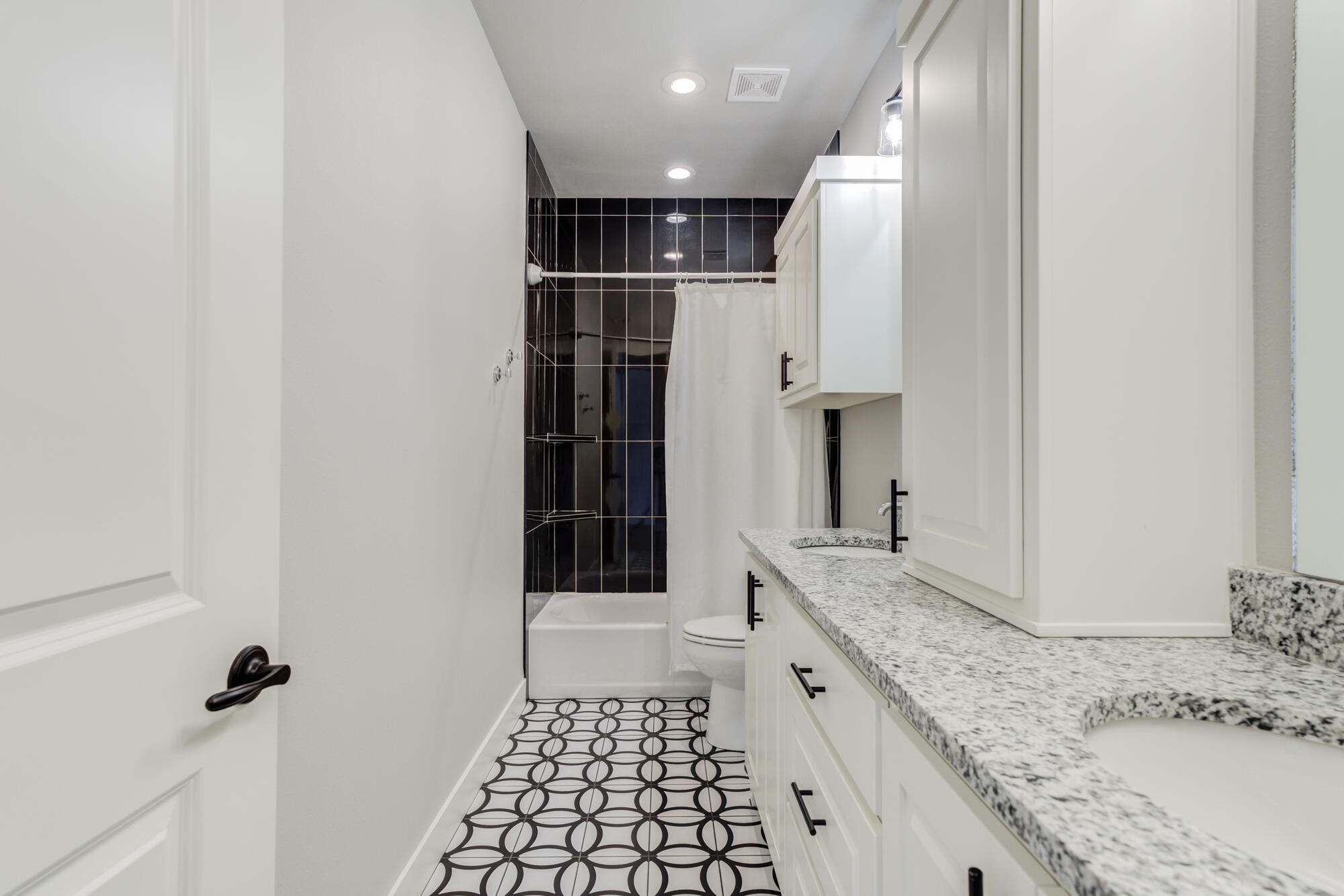5611 117th Street Lubbock, TX 79424 - Photo 25 of 30 a bathroom with a granite countertop sink a toilet and a shower