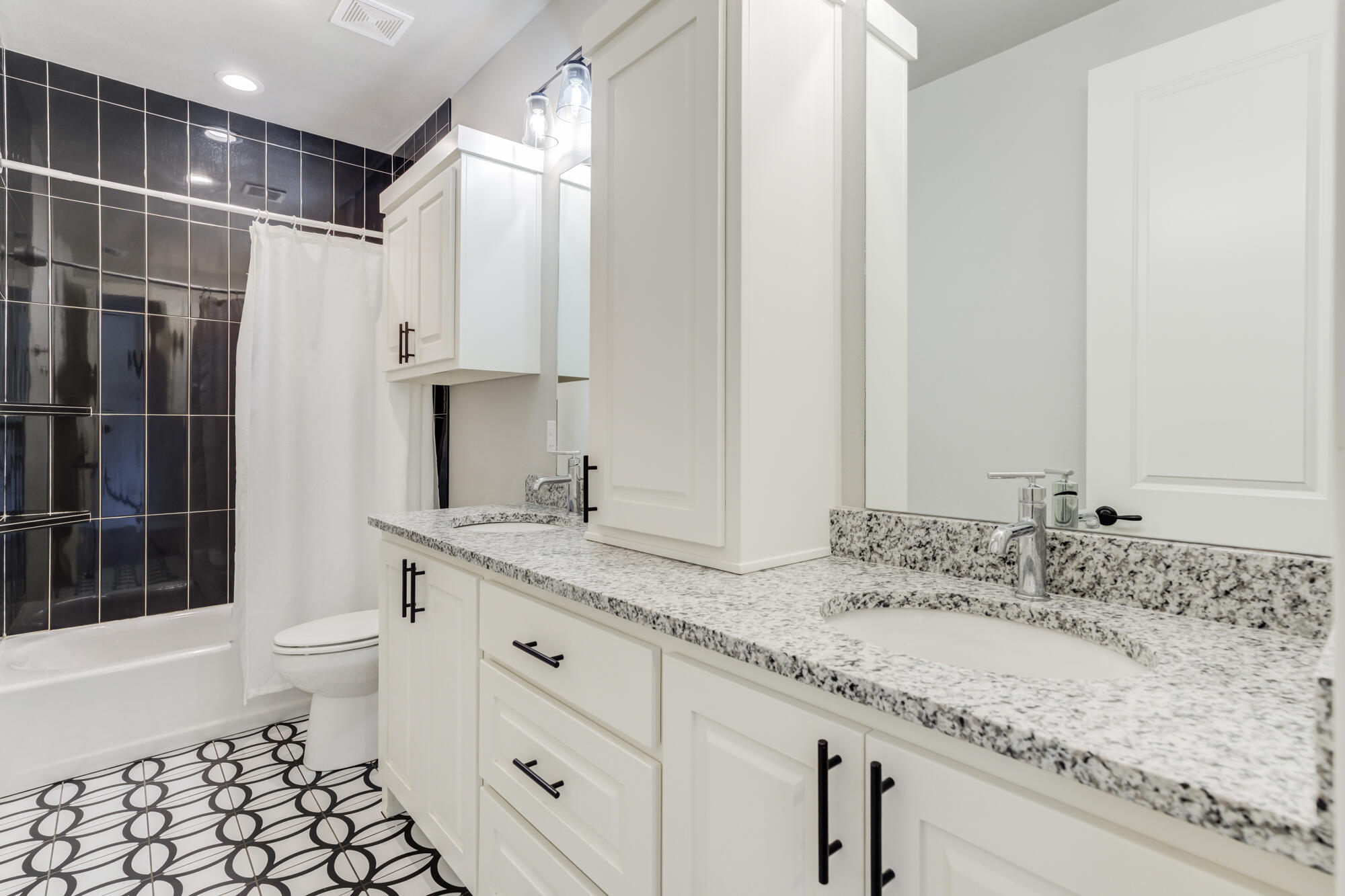 5611 117th Street Lubbock, TX 79424 - Photo 26 of 30 a bathroom with a granite countertop sink a toilet and shower