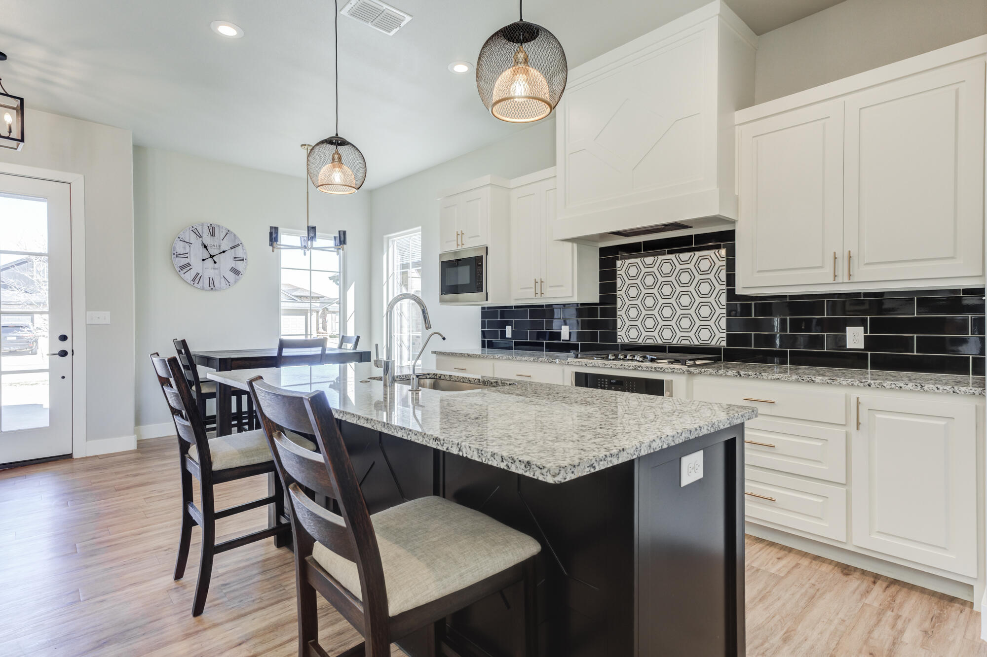 5611 117th Street Lubbock, TX 79424 - Photo 5 of 30 a kitchen with stainless steel appliances granite countertop a stove a sink a dining table and chairs with wooden floor