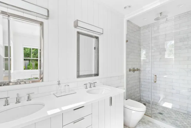 a bathroom with a double vanity sink toilet and shower
