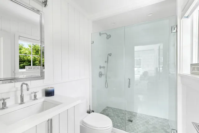 a bathroom with a sink a toilet and shower