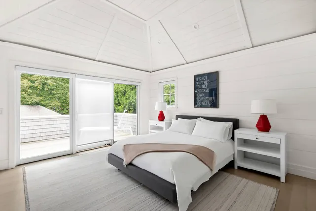 a bedroom with a bed wooden floor and window
