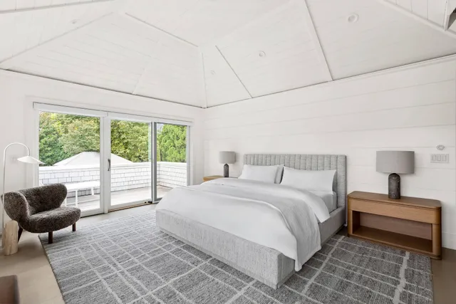 a bedroom with a bed and a couch next to a window