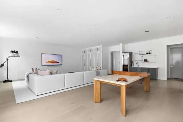 a living room with furniture a table and white walls