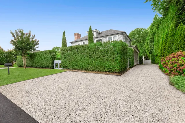 a view of a back yard with flower plants and wooden fence