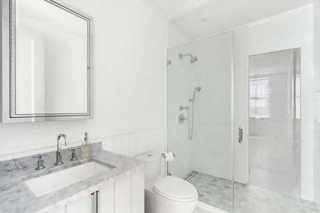 a bathroom with a granite countertop sink toilet a mirror a vanity and shower