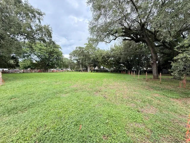 a view of a green field with trees in the background