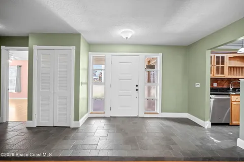 an empty room with windows and ceiling fan
