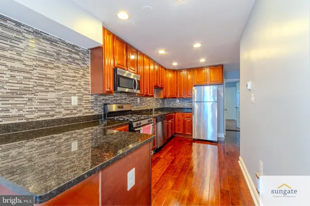 a kitchen with stainless steel appliances granite countertop a refrigerator and a stove