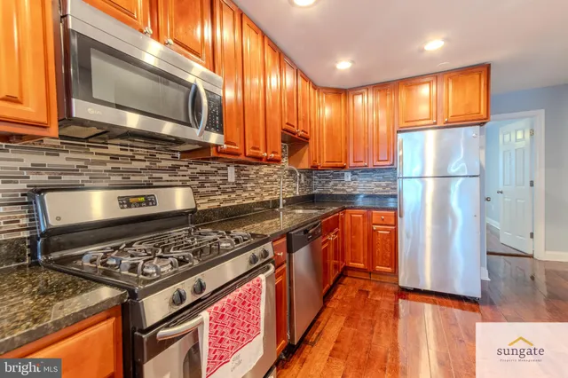 a kitchen with stainless steel appliances granite countertop a stove a sink and a microwave