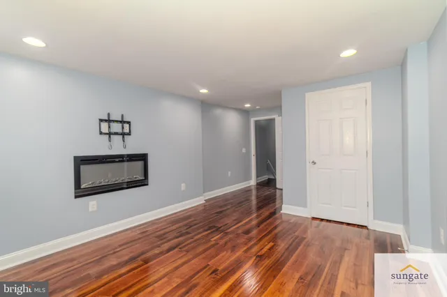a view of a hallway with wooden floor and a ceiling fan