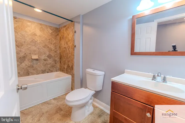 a bathroom with a sink a toilet a mirror and shower