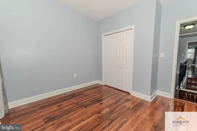 an empty room with wooden floor and closet