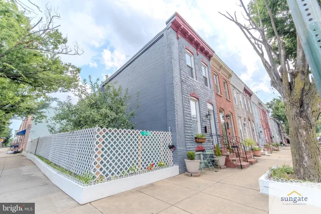 a view of a brick house with large trees