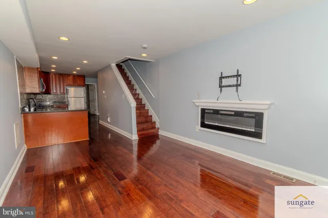 a view of a kitchen with wooden floor and electronic appliances