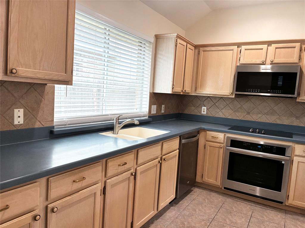 7936 Tournament Road Frisco, TX 75035 - Photo 8 of 28 a kitchen with cabinets appliances and a sink