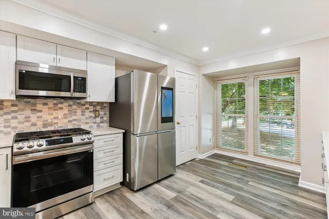 a view of a kitchen with wooden floor and doors